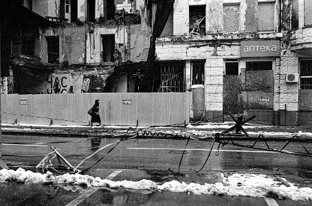 Person vor zerstöreten Wohnhäusern, Ukraine